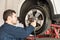 Worker Using Impact Wrench On Change Tire