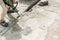 worker using jackhammer drilling concrete surface
