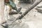 Worker using jackhammer drilling concrete surface