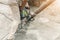 Worker using jackhammer drilling concrete surface