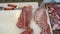 Worker using knife cutting pieces of lamb meat. Deboning of lamb meat. Butcher in gloves cuts carcass of red meat into pieces.