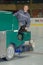 Worker using machine to clean ice at ice skate rink