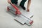 Worker using manual tile cutter indoors, closeup