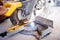 Worker using mitre saw for cutting wood parquet