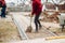 Worker using pavement slabs and shovel to build stone sidewalk. Close up of construction worker installing and laying pavement sto