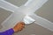 Worker using plaster gypsum on putty knife at ceiling