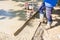 Worker is using power tool with engine, compactor, for level and compact fresh concrete