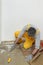 Worker using putty knife for cleaning floor