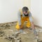 Worker using putty knife for cleaning floor