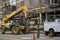 A worker using a telescopic forklift raises a load of bricks during installation of brick veneer on a new building