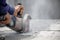 Worker using tool to cut concrete floor with blank space on right