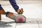 Worker using tool to cut concrete floor with blank space on right