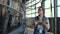 Worker walk milking parlour at dairy facility. Woman inspect suction machinery.