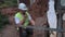 Worker with walkie talkie near tractor tire