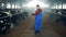 Worker is walking along the cowhouse and observing cows. Modern farmer.