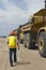 Worker Walking Near Trucks At Landfill Site