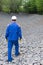 A worker walks on stones laid at the bottom under an artificial lake