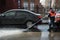 A worker washes the street in places where cars are parked