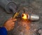 Worker welding metal exhaust pipe with sparks