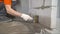 Worker wets the concrete floor with a brush. Primer concrete floor for waterproofing