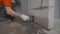 Worker wets the concrete floor with a brush. Primer concrete floor for waterproofing