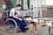 Worker in wheelchair in a carpenter\'s workshop