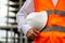 Worker with white safety helmet and orange vest. Construction and industrial site workers concept