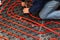 Worker who instal tubes of radiant underfloor heating installation