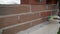 Worker wipes the seams outside the brick house. The builder processes the brickwork. Construction mason worker