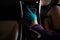 Worker women wear green gloves cleaning car interior gear head with gray microfiber cloth