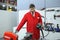 Worker in work clothes and protective glasses switching the control panel on to sand metal sheet by the hand held pneumatic belt