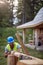 Worker working with drilling machine on wooden construction. Carpenter building wooden home