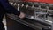 The worker works on the bending machine in an industrial enterprise. Close-up of the machine and the hands of the worker.