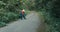 Worker in workwear and on highway in forest measures roadway with tape measure