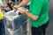 Worker wrapping suitcase with transparent protection film atairport deparure terminal before flight. Luggage protection