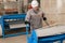 Workers adjusts the machine in the warehouse. the production of ventilation and gutters. Tool and bending equipment for