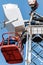 Workers on an aerial platform with the help of a crane carry out the installation of a wind turbine