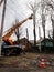 Workers on aerial work platform, on truck, prune tree branches among electricity lines in a village Ukraine. Pollarding process