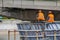 Workers assemble the structure of the bridge and the people sat down to rest.