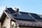 Workers building solar panel system on roof of house. Installers carrying photovoltaic solar module