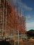 Workers climb iron scaffolding