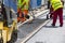 Workers construct asphalt road and railroad lines