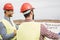 Workers engineers discussing about the new building area - Young builders reading the project in the construction site