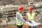 Workers engineers discussing about the new building area - Young builders reading the project in the construction site