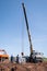 Workers and engineers, truss and truck crane at a construction site