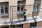 Workers erect scaffolding to repair the facade of a building