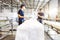 Workers in a factory carry out technological processes on a conveyor line in protective overalls