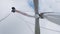 Workers fix wind-driven generator blade under cloudy sky