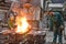 workers in a foundry casting a metal workpiece - safety at work and teamwork