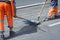 Workers hands asphalting repair the road on the street using asphalt trowels